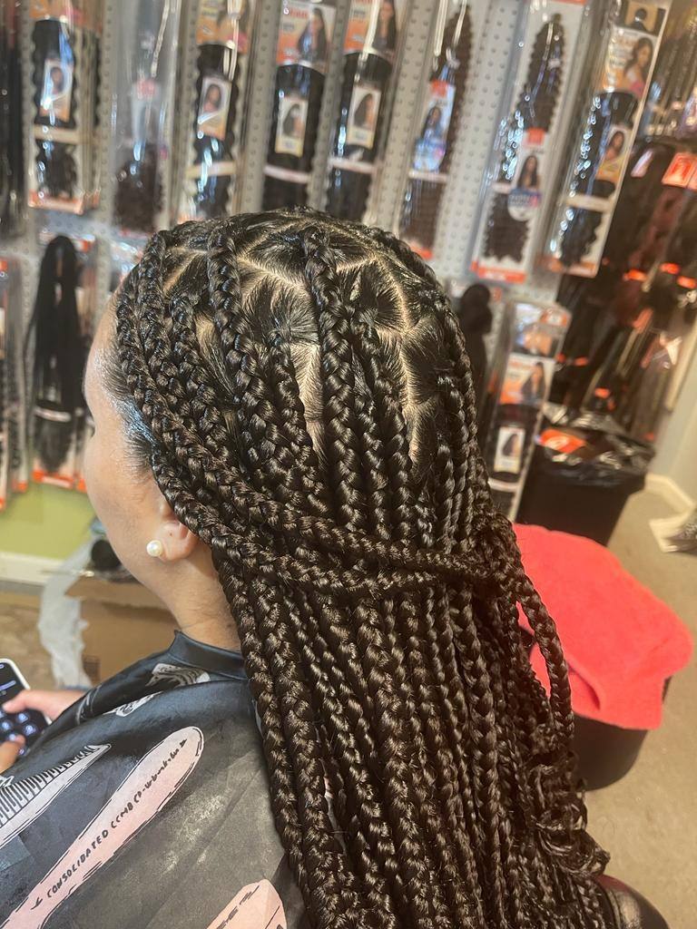 Medium knotless braids from crisp triangular partings, side view